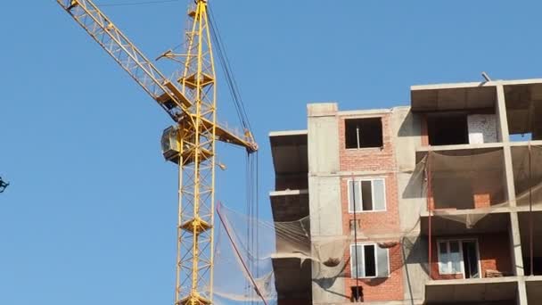 Working on place with many tall buildings under construction and cranes under a blue sky — Stock Video