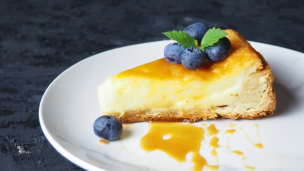 Φέτα νόστιμο cheesecake με φρούτα μούρο σε ένα μαύρο τραπέζι. — Αρχείο Βίντεο