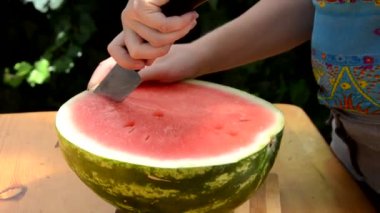 Üç parça karpuz doğrama kalıbının üzerine konmuş. Helikopter bir parça karpuzu bıçakla kesiyor. Tayland 'da yaz mevsimi. Herkes karpuz yerken çok lezzetli ve taze.