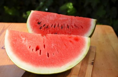 Üç parça karpuz doğrama kalıbının üzerine konmuş. Helikopter bir parça karpuzu bıçakla kesiyor. Tayland 'da yaz. Herkes karpuz yerken çok lezzetli ve taze.