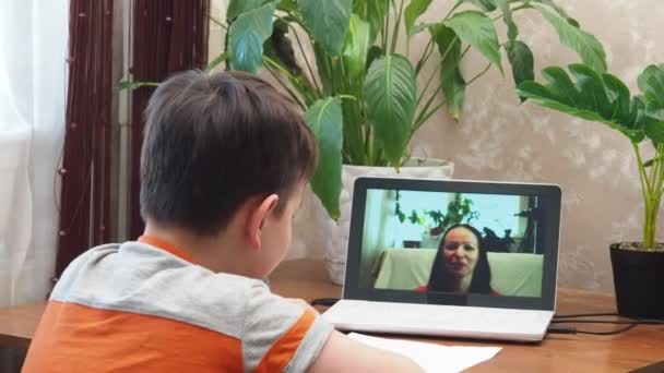 Un niño preadolescente inteligente sentado en la mesa, escribiendo tareas o preparándose para el examen. Adolescente usando la computadora portátil para estudiar. Estudiante, Escuela, Remoto, Aprendizaje en línea, Nuevo normal, Aprendizaje basado en el hogar. — Vídeo de stock