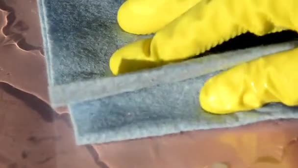 Primer plano de las manos con guantes protectores de goma amarilla limpiando la superficie blanca con un trapo. Hogar, concepto de limpieza — Vídeo de stock