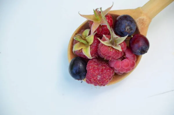 Raspberry musim panas hutan dan blueberry dalam sendok di atas meja putih — Stok Foto