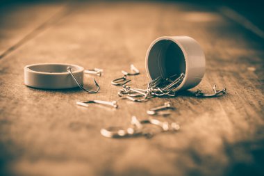 Balık tutma kancaları tahta üzerinde dağınık bir kavanozdan geldi.