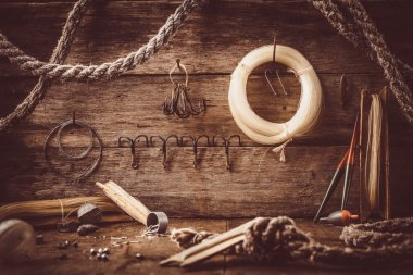 Eski bir ahırda bir rafta balıkçılık aksesuarları dağılın.