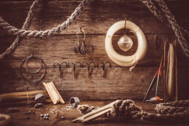 Eski bir ahırda bir rafta balıkçılık aksesuarları dağılın.