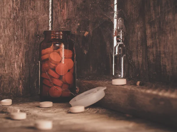 Pills in a jar on a shelf of old cobwebby.