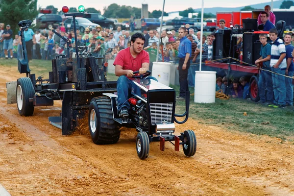 Férfi vezetési traktor húzza verseny: Stock Fotó