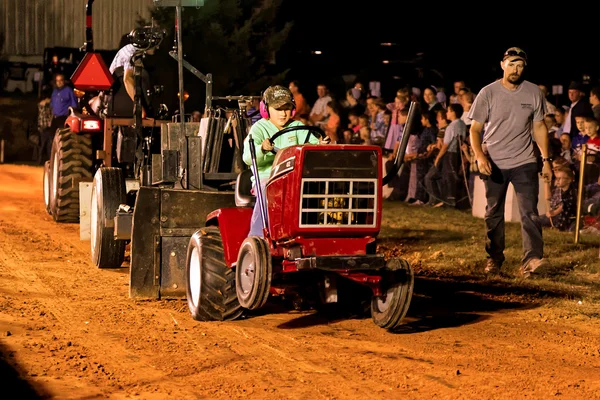 Flickan kör traktor på att dra konkurrens — Stockfoto