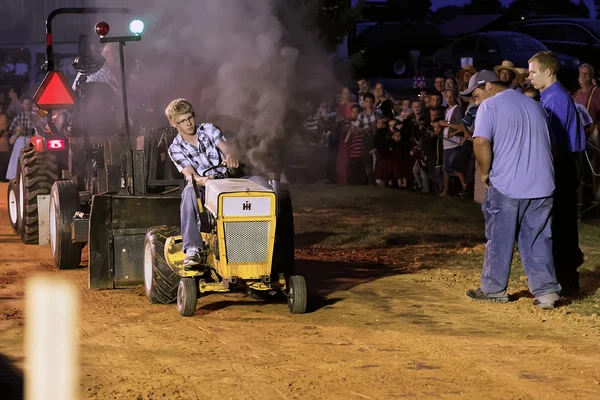 Pojke köra traktor på att dra konkurrens — Stockfoto