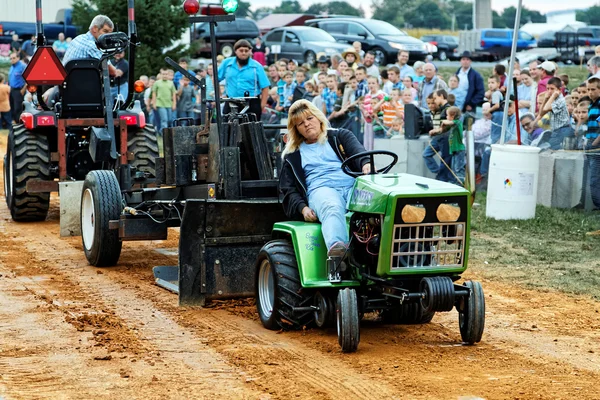 Kvinnan kör traktor på att dra konkurrens — Stockfoto