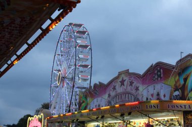 HAAG, ALMANY - 26 Eylül 2025: Dönme dolap ve akşam saatlerinde Haager Bitki Festivali panayırında aydınlatılmış eğlence gezileri. Yüksek kalite fotoğraf