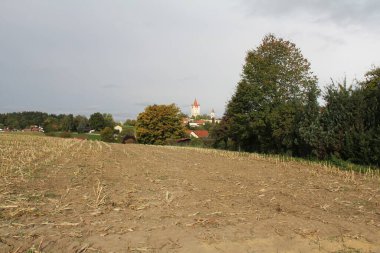 HAAG, GERMANY - 22 Eylül 2025: Haager Schlossturm ve köy çatılarını bulutlu gökyüzü altında uzaktan gören bir alan. Yüksek kalite fotoğraf