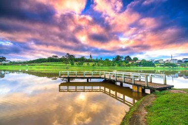 Aşk köprüsündeki şafak dramatik gökyüzü ile göle bakan Vietnam 'da yeni bir günü karşılıyor.