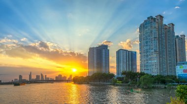 Ho Chi Minh Şehri, Vietnam - 17 Ocak 2021: Nehir boyunca kentsel alanlarda gün batımı gökdelenlerin parlaklığı çarpıcı bir şekilde görülüyor Ho Chi Minh Şehri, Vietnam 'da kentsel gelişimin güzelliğini yaratıyor