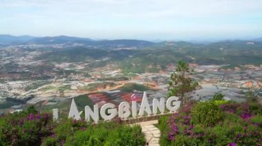 Vietnam 'ın dağlık kesimlerinde tarım için sebze ve çiçek yetiştiren küçük köylerin bulunduğu vadiye bakan dağın en üst manzarası.