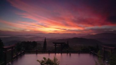 Tapınak kapısının önündeki şafak, gökyüzünde etkileyici renkli bulutlar sis vadisinin altında turistleri rahatlatmak, Da Lat, Vietnam yakınlarında meditasyon yapmak için parlıyor.