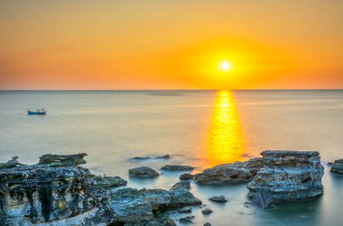 Soyut kireçtaşı sahilinde gün batımı Pearl Island Phu Quoc, Vietnam 'da denize bakıyor. Mekan eko-turizm ve keşifler için bozulmamış durumda.