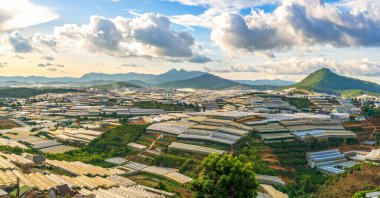 Sunset scene in valley with greenhouses to plant flowers and vegetables. The place that supplies fresh agricultural products and flowers to the highlands of southern Vietnam