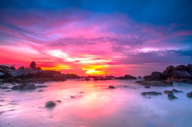 Beautiful sunrise on the beach below the waves lapping at the shore of the soft great to welcome the peaceful new day