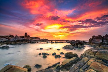 Beautiful sunrise on the beach below the waves lapping at the shore of the soft great to welcome the peaceful new day