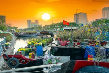 Ho Chi Minh City, Vietnam - 9 Şubat 2021: Kanal iskelesi boyunca gün batımı tekne iskelesi çiçek pazarı. Burası çiftçilerin kayısı ve diğer çiçekleri sattığı yer Ho Chi Minh şehrinde yeni yılda, Vietnam 'da.