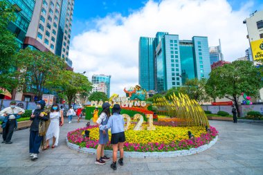 Ho Chi Minh Şehri, Vietnam - 9 Şubat 2021: Sokak boyunca süslenmiş çiçeklerle yürümekte olan Lunar Yeni Yılı, Ho Chi Minh Şehri, Vietnam 'da pek çok turisti cezbediyor.