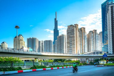 Ho Chi Minh şehri, Vietnam, 27 Şubat 2021: Nehir kenarındaki yüksek kentsel alanın yanındaki köprüdeki trafik, Ho Chi Minh şehrindeki refah ekonomik kalkınmayı temsil ediyor
