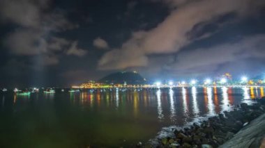 Güzel bir körfezde, gün batımında ve gece. Hafta sonu dinlenmek için bir sürü balıkçı teknesi kenetlendi.