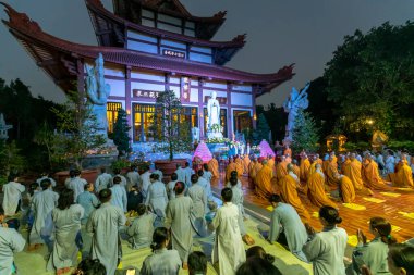 Ho Chi Minh Şehri, Vietnam - 12 Aralık 2019: Keşişler ve Budistler, Vietnam 'ın Ho Chi Minh şehrindeki antik bir tapınakta Amitabha Buda' nın akşam töreni sırasında Buda 'ya saygılarını sunuyorlar.