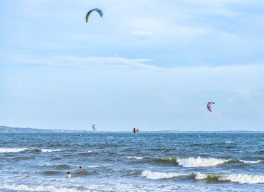 Arka planda denizde uçurtma uçurmak.