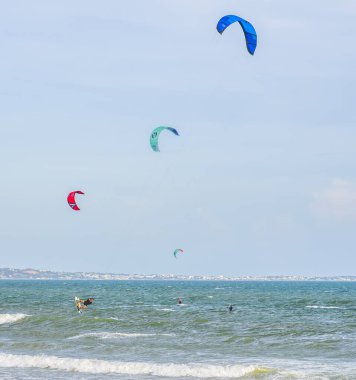 Sahilde denizde sörf yapan uçurtma.