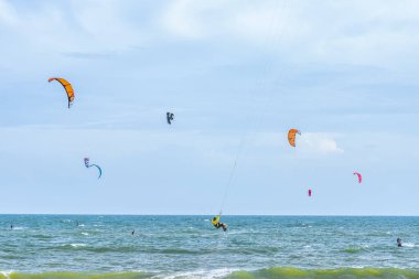 Denizin sahilinde uçurtma sörfü. Mavi gökyüzünün arka planında güzel bir deniz. Uçurtmada uçurtma.