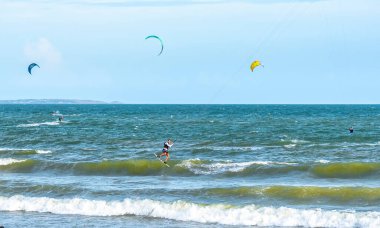 Denizde uçurtma uçuran bir adam.