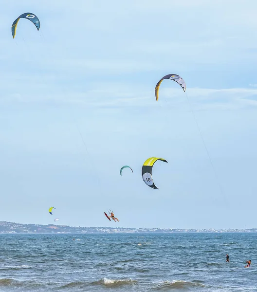 Mavi gökyüzü arka planıyla denizde sörf yapan uçurtma..