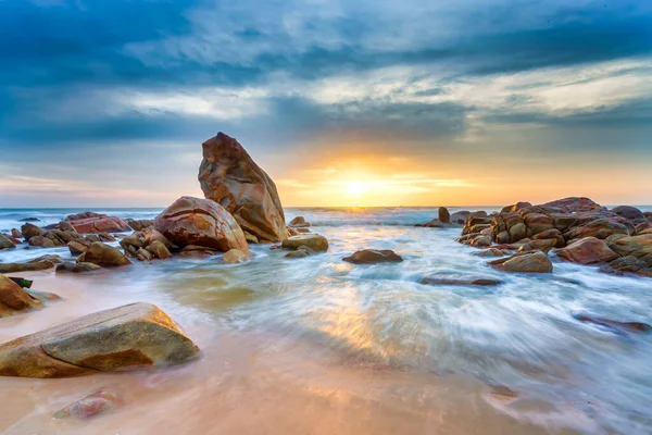 Güneşin doğuşu güzel kumsalın kayalık sahillerinde