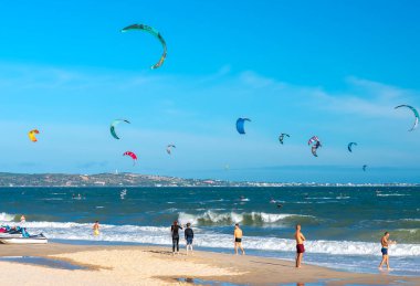 Sahilde uçurtma sörfü yapan insanlar.