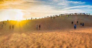 Turistler gün batımında kum tepelerinde, Dubai 'de, uae
