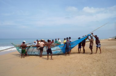 Induruwa, Sri Lanka-Mar 24: Sri Lankalı balıkçılar ve plaj Induruwa, Sri Lanka, teknelerinde .