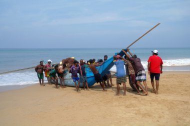 Induruwa, Sri Lanka-Mar 24: Sri Lankalı balıkçılar ve plaj Induruwa, Sri Lanka, teknelerinde .