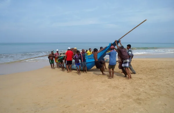 INDURUWA,SRI LANKA -MAR 24th:  Sri Lankan fishermen and their boat on the beach at Induruwa,SRI LANKA . — Stock Photo, Image