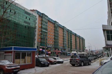 Bu resim park önü olan yeşil bir binayı gösteriyor.