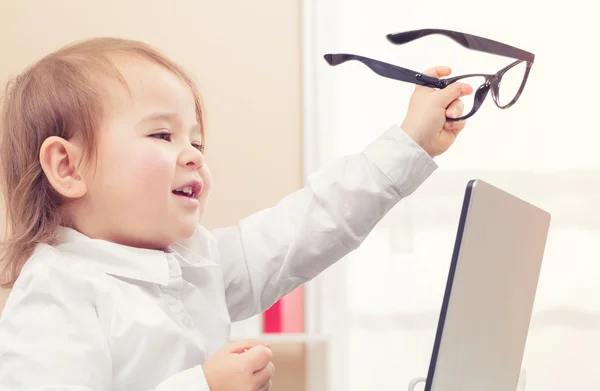 Kleuter meisje met bril met behulp van haar laptop — Stockfoto
