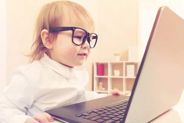Kleuter meisje met bril met behulp van haar laptop — Stockfoto