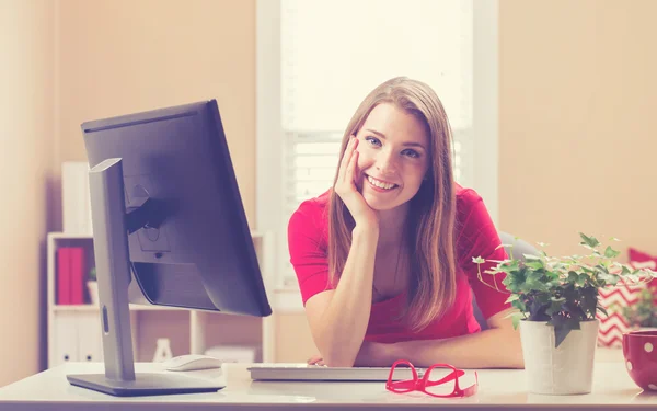 Mulher sorrindo em seu escritório em casa — Fotografia de Stock