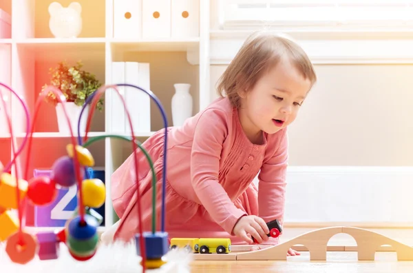 Ευχαρίστως toddler κορίτσι παίζει με τα παιχνίδια — Φωτογραφία Αρχείου