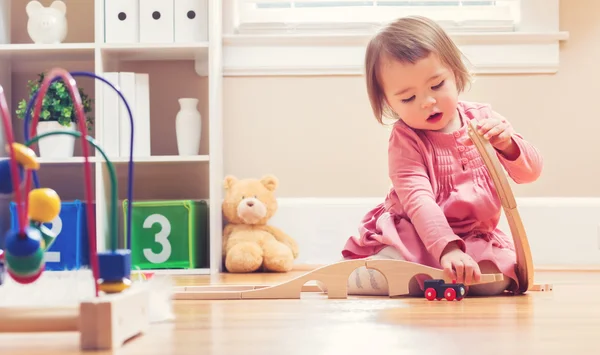 Ευχαρίστως toddler κορίτσι παίζει με τα παιχνίδια — Φωτογραφία Αρχείου