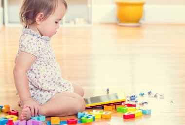 yürümeye başlayan çocuk kız onun tablet bilgisayar ile oynamak