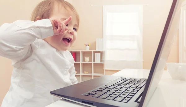 Chica riendo mientras usa su portátil — Foto de Stock