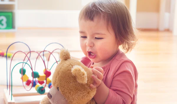 Ευχαρίστως toddler κορίτσι παίζει με το αρκουδάκι — Φωτογραφία Αρχείου